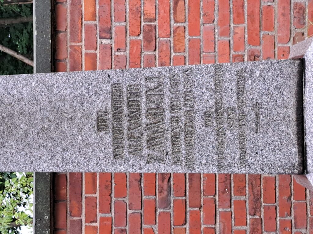 Detail zvětralého nápisu na žulovém obelisku Alexandra Zawadského.